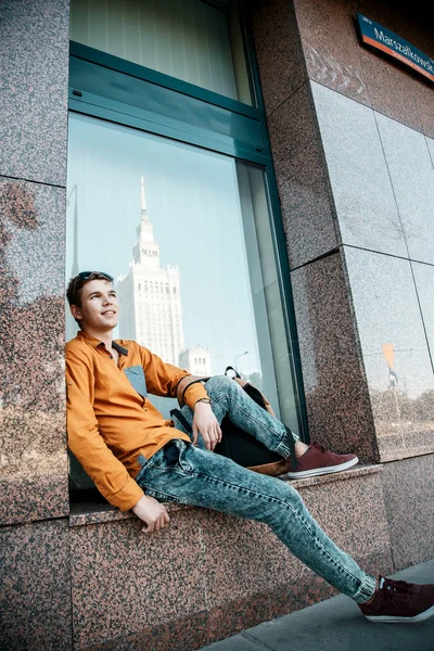 Şık giyinmiş genç adam Varşova sokaklarında. Kent merkezindeki adam. Avrupa şehir seyahat. Evrak çantalı adam. Kırmızı bir vida ile genç bir adam. Genç bir öğrenci eğitim için bir şeyin peşinde. Bir adam işe gider.