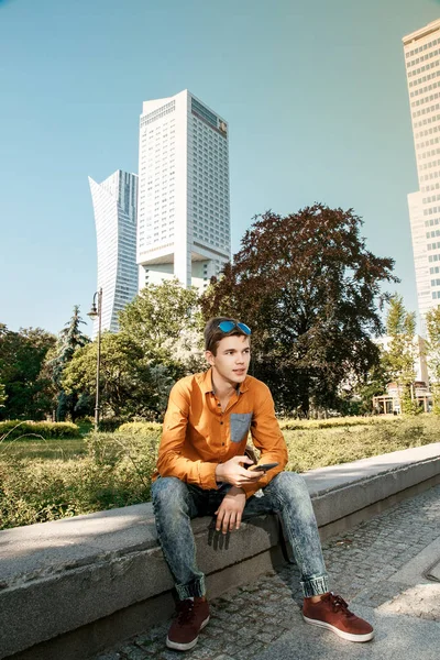 Şık giyinmiş genç adam Varşova sokaklarında. Kent merkezindeki adam. Avrupa şehir seyahat. Evrak çantalı adam. Kırmızı bir vida ile genç bir adam. Genç bir öğrenci eğitim için bir şeyin peşinde. Bir adam işe gider.