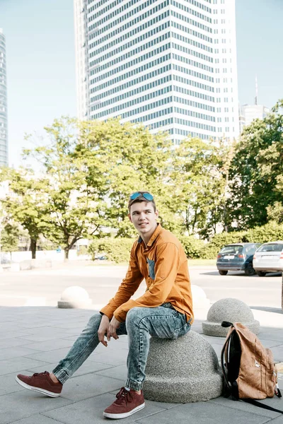 Şık giyinmiş genç adam Varşova sokaklarında. Kent merkezindeki adam. Avrupa şehir seyahat. Evrak çantalı adam. Kırmızı bir vida ile genç bir adam. Genç bir öğrenci eğitim için bir şeyin peşinde. Bir adam işe gider.