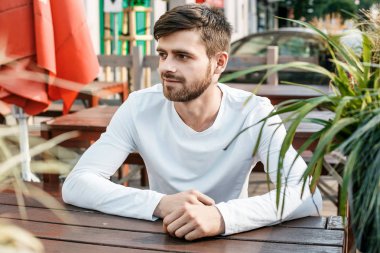 Genç adam sokakta. Gözlüklü building yakınındaki şık adam. Sevimli bir adam bir toplantı için bekler. Erkekler düşünceler. Kaldırımda oturan adam. Varşova, Polonya, Lehçe, Warszawa. öğrenci sınıfları, okul, öğrenci, sınıflar, eğitim, mutlu, c sonra