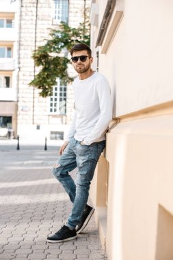 Genç adam sokakta. Gözlüklü building yakınındaki şık adam. Sevimli bir adam bir toplantı için bekler. Erkekler düşünceler. Kaldırımda oturan adam. Varşova, Polonya, Lehçe, Warszawa. öğrenci sınıfları, okul, öğrenci, sınıflar, eğitim, mutlu, c sonra