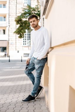 Genç bir adam şehrin sokaklarında dolaşıyor. Çocuk güneş gözlüğü şık adamın binanın yanında. Adam bir kamçı üzerinde oturur. Sakal ve saç, şık bir adamda.