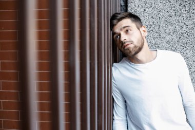 Genç bir adam şehrin sokaklarında dolaşıyor. Çocuk güneş gözlüğü şık adamın binanın yanında. Adam bir kamçı üzerinde oturur. Sakal ve saç, şık bir adamda.