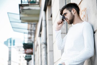 Genç bir adam şehrin sokaklarında dolaşıyor. Çocuk güneş gözlüğü şık adamın binanın yanında. Adam bir kamçı üzerinde oturur. Sakal ve saç, şık bir adamda. Eğitim sonra kıdemli öğrenci.