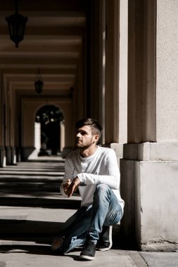 Genç bir adam şehrin sokaklarında dolaşıyor. Çocuk güneş gözlüğü şık adamın binanın yanında. Adam bir kamçı üzerinde oturur. Sakal ve saç, şık bir adamda. Kıdemli öğrenci eğitim sonra. çocuk sokakta. Adam şehir.