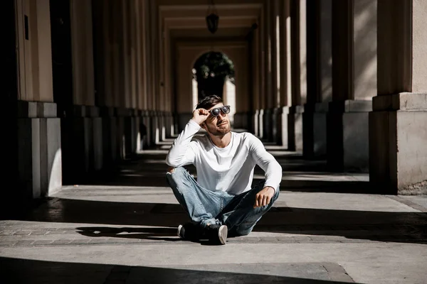 Genç bir adam şehrin sokaklarında dolaşıyor. Çocuk güneş gözlüğü şık adamın binanın yanında. Adam bir kamçı üzerinde oturur. Sakal ve saç, şık bir adamda. Eğitim sonra kıdemli öğrenci.