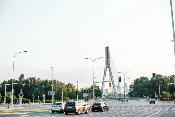 Street of the city. Road and bridge over the Wisla River in Warsaw. Swietokrzyski Bridge in Warsaw. Street Traffic Cars on the road. Poland.