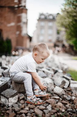 Taş olan bir çocuk. Çocuk tarihi binanın çevresinde oynuyor. Church yakınındaki avluda. Krakow şehrinde küçük çocuk