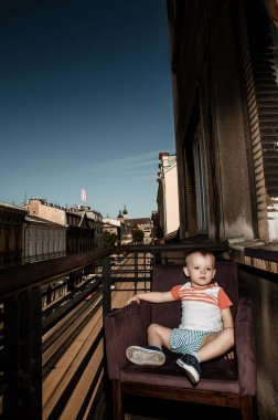 Anne ile bebeği balkonda. Genç anne oğluyla sarılma. Aile city.krakow Caddesi'nde arıyor. Polska.