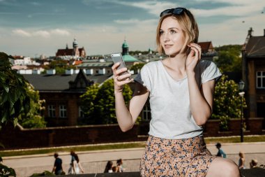 Krakow'daki Wawel Castle. Bir cep telefonu olan bir genç kadın. bir kadın bir cep telefonu konuşuyor. Krakow. Krakow için seyahat. Genç kadın güneş gözlüğü. Krakow tarihi binalarda. City adlı görünüyor.