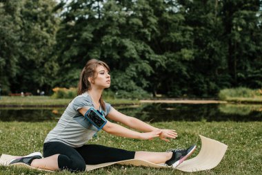 Genç modern kentin merdivenlerde bacak germe kadın spor. Sağlıklı yaşam büyük şehirde. Sabah egzersiz sırasında açık havada müzik rahatlatıcı spor kadın. spor kadın parkta sabah exesrcis sırasında germe