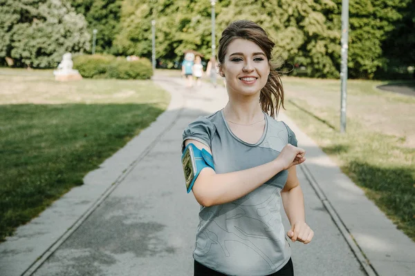 Young sports woman stretching legs on the stairs in the modern city. Healthy lifestyle in the big city. Sports woman relaxing listening to the music during the morning exercise outdoors. sports woman stretching in the park during the morning exesrcis