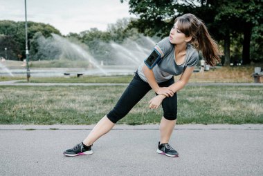 : Açık spor yapıyor, Genç ve güzel bir kız. Parkta kız spor çalışmaları gerçekleştirir..