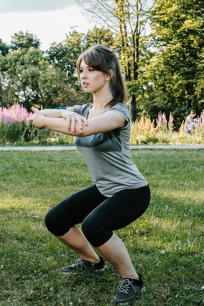 Young sports woman stretching legs on the stairs in the modern city. Healthy lifestyle in the big city. Sports woman relaxing listening to the music during the morning exercise outdoors. sports woman stretching in the park during the morning exesrcis