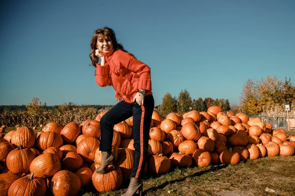 Young woman on a pumpkin farm. Beautiful girl near pumpkins. A girl with a pumpkin. Pumpkin Field.