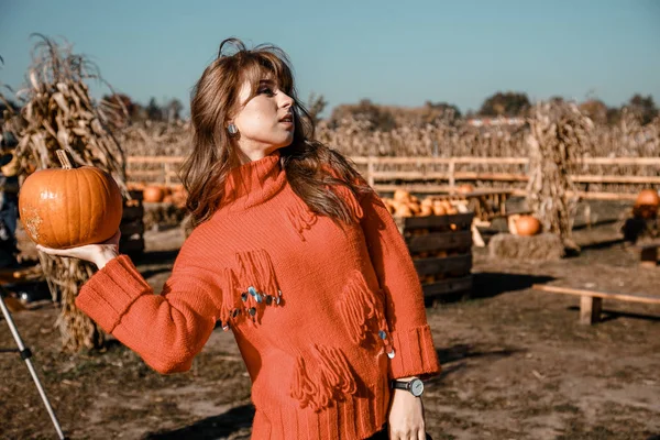 Young woman on a pumpkin farm. Beautiful girl near pumpkins. A girl with a pumpkin. Pumpkin Field.