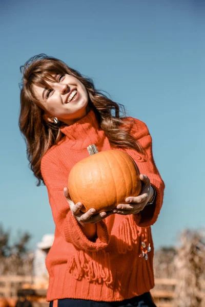 Young woman on a pumpkin farm. Beautiful girl near pumpkins. A girl with a pumpkin. Pumpkin Field.