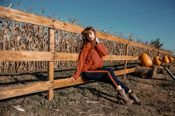Young woman near corn. beautiful girl in the village. Autumn.