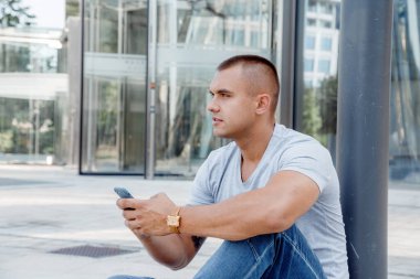 Elinde cep telefonu olan bir adam. Saati ve telefonu olan bir adam..