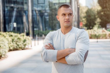 Adam elleri bağlı bir şekilde ayakta duruyor. Camdan evin yanındaki genç adam. Liderlik insan kişiliği kavramı.