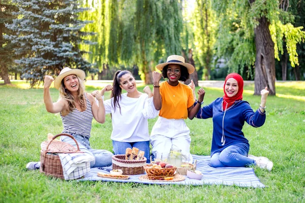 Young multiracial women are on picnic in the park. Women\'s power.