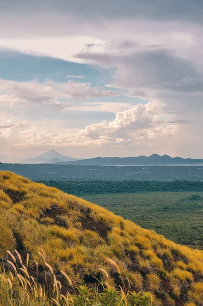 Momotombo yanardağının önü çimlerle kaplı bir tepeyle Masaya volkanı ulusal parkının tepesinden harika bir manzara.