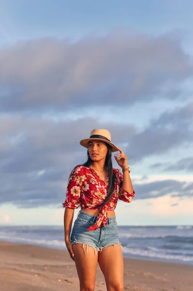 Gün batımında sahilde genç ve güzel bir kadın.