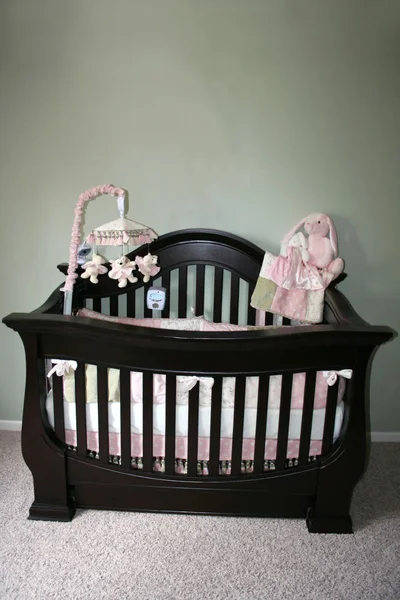 Bir güzel şık koyu ahşap beşik pembe desenli.