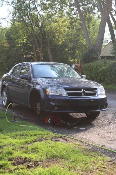 Bir jak üzerinde düz bir lastik ile bir araba güzel güneşli bir fotoğraf. Mekanik arıza. 