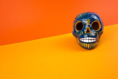 Ölü ya da Cadılar Bayramı yaratıcı ve minimal günün düzeni. Kafatası turuncu zemin üzerine. Düz yatıyordu önden görünüm. Kopya alanı