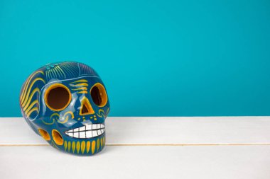 Ölü ya da Cadılar Bayramı yaratıcı ve minimal günün düzeni. Kafatası mavi Kağıt arka plan üzerinde. Düz yatıyordu önden görünüm. Kopya alanı