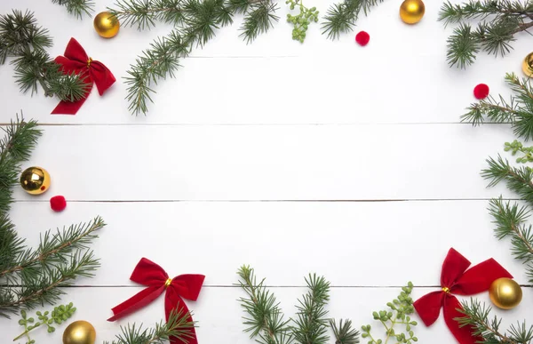 Yaratıcı Noel düzeni. Köknar twigs, kırmızı kurdele ve altın top. Beyaz tahta arka plan beyaz kopya alanı. Kenarlık düzenleme. Düz yatıyordu üstten görünüm. 