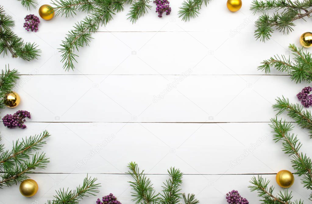 Creative Christmas layout. Fir twigs and golden balls. White wood background whit copy space. Border arrangement. Flat lay top view. 