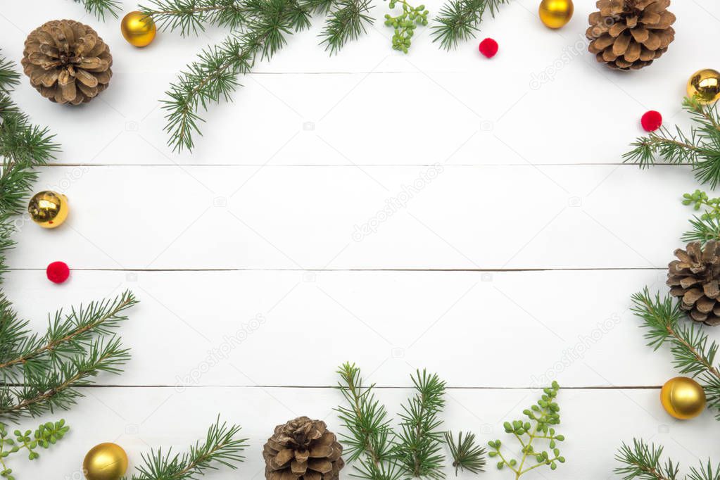 Creative Christmas layout. Fir twigs, pinecones and golden balls. White wood background whit copy space.  Border arrangement. Flat lay top view. 