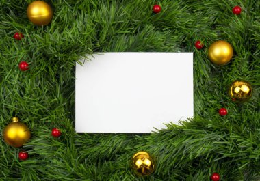 Yaratıcı Noel düzeni. Beyaz kart kopya alanı üzerinde yeşil gelin teli ile. Kırmızı ve altın top. Kenarlık düzenleme. Düz yatıyordu üstten görünüm.