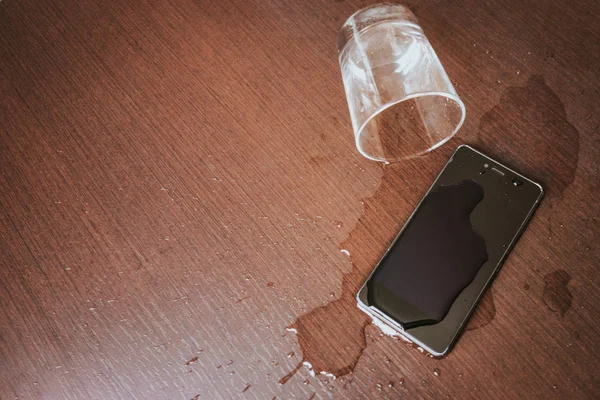 Ahşap Masa Üzerinde Kazara Islak Smartphone Bardak Döktü — Stok fotoğraf