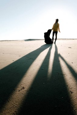 Çöp ve plastik toplayan kadın çöp torbasıyla plajı temizliyor. İklim değişikliği ve okyanusların kirliliğine karşı çevre gönüllü aktivisti.