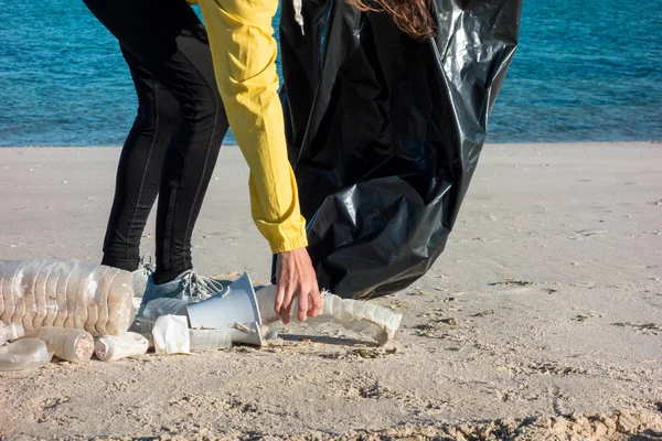 女人捡垃圾和塑料 用垃圾袋清理海滩 反对气候变化和海洋污染的环境志愿者活动家 — 图库照片