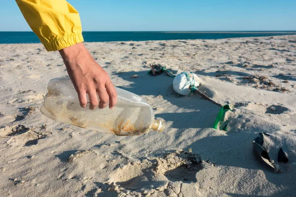 Çöp ve plastik toplayan kadın çöp torbasıyla plajı temizliyor. İklim değişikliği ve okyanusların kirliliğine karşı çevre gönüllü aktivisti.