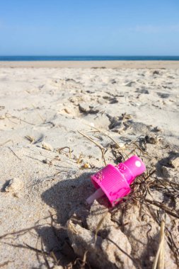 Plaj kumunda pembe sprey kapağı. Okyanuslar kavramının plastik kirliliği.