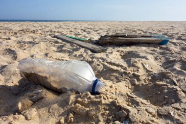 Kum kumundaki plastik şişe. Okyanuslar kavramının plastik kirliliği.