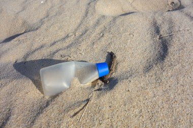 Kum kumundaki plastik şişe. Okyanuslar kavramının plastik kirliliği.