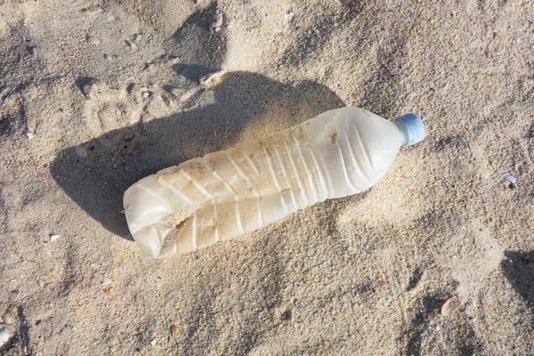 Kum kumundaki plastik şişe. Okyanuslar kavramının plastik kirliliği.