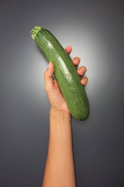 Gri arka planda bir kabak tutan el