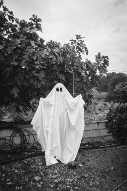 Hayalet, ormanda beyaz bir hayalet örtüsüyle kaplanmış. Cadılar Bayramı Konsepti