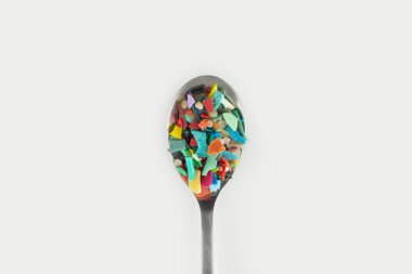 Bir kaşık dolusu mikro plastik. Plastik kirliliği kavramı.