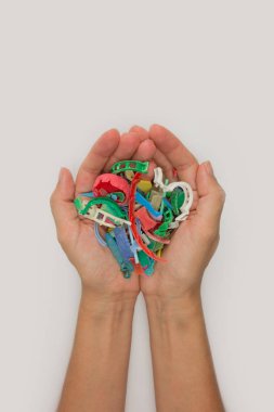 Elleri plajda toplanan mikroplastiklerle dolu. Plastik kirliliği kavramı.