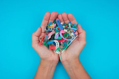 Elleri plajda toplanan mikroplastiklerle dolu. Plastik kirliliği kavramı.