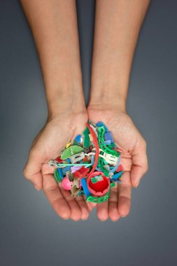 Elleri plajda toplanan mikroplastiklerle dolu. Plastik kirliliği kavramı.
