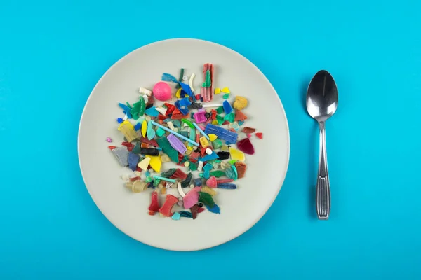 Plate full of microplastics. Plastic pollution concept.